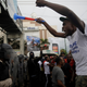 A protester confronts Haitian national police officers during a Sept. 20 Port-au-Prince demonstration sparked by the shortage of fuel.